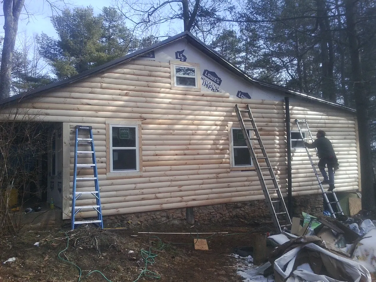 Ladders set against fresh log siding during an exterior remodel in Green Pond