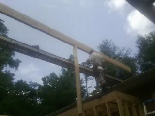 Carpenter setting a ridge beam over a new addition frame — Ice Dam Removal by Roofing Brothers in Green Pond
