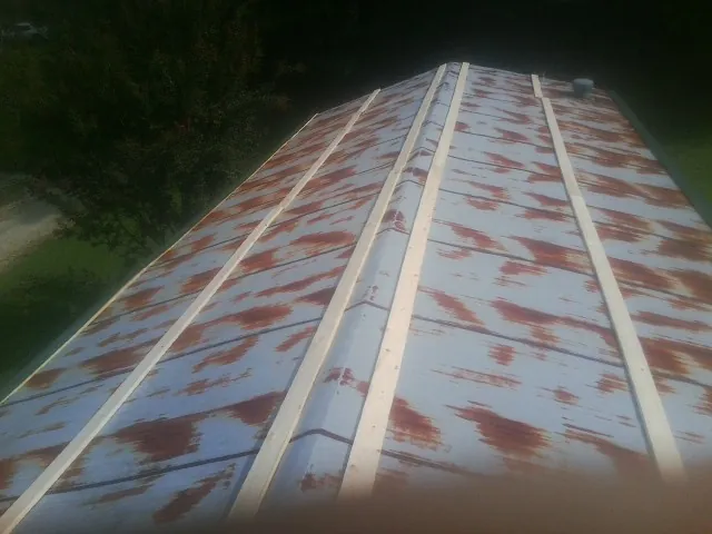 Rusted metal roof panels with new wood purlins before replacement — Storm Damage Roof Repair in Green Pond by Roofing Brothers