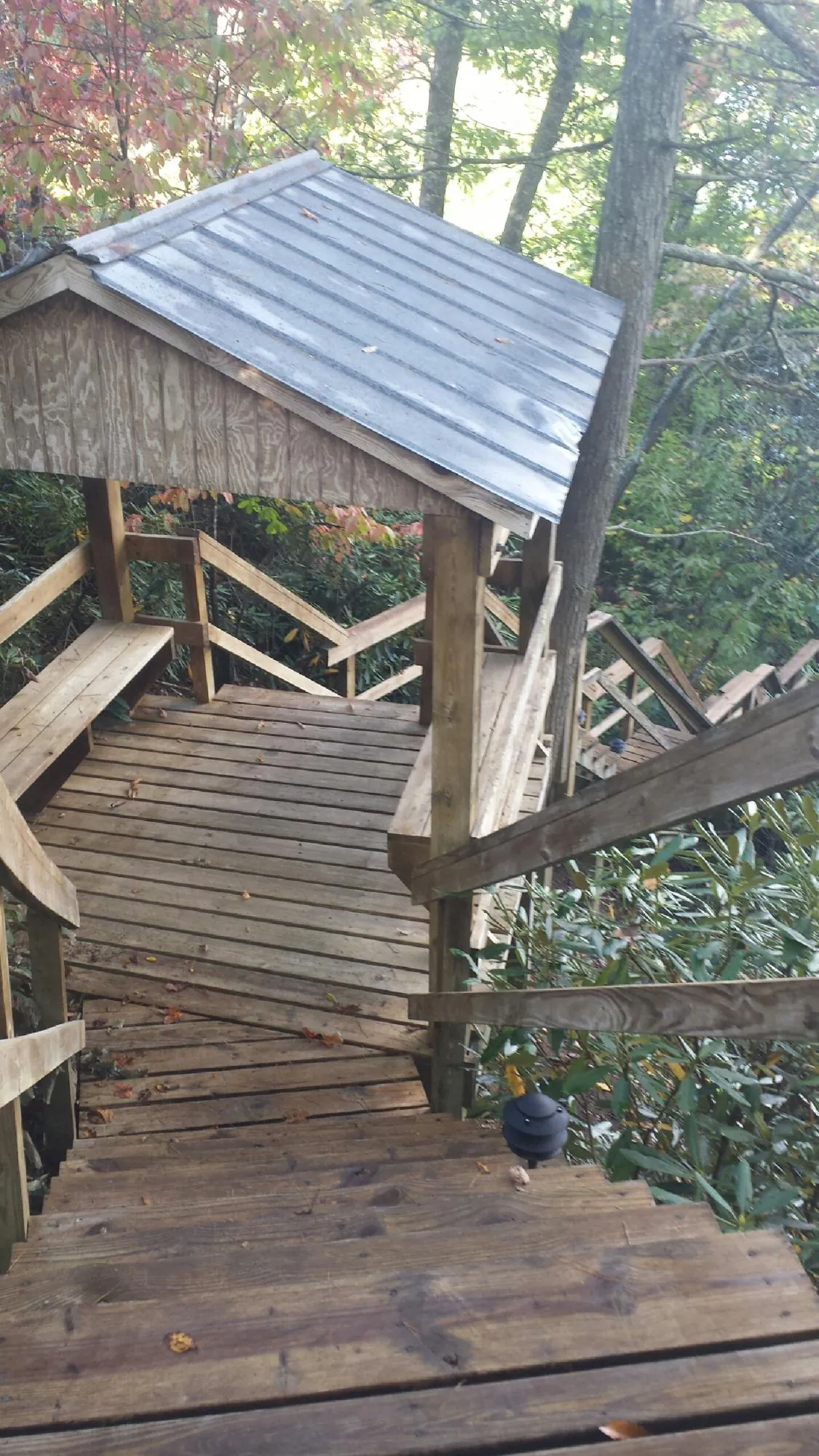 Metal roofed shelter over wooden steps on a wooded walkway — Skylight Repair & Installation work by our crew in Green Pond